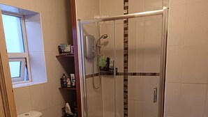Un baño con inodoro, ducha y lavamanos.