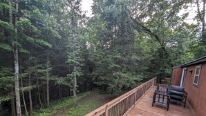 A wooden deck with a railing, a small table, and two chairs, surrounded by dense forest. - Horse-Friendly Retreat:Trail Access, Woodland Views & Peaceful Deck (Allardt)
