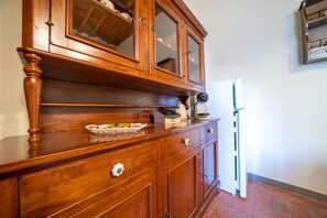 Eine Küche mit Holzschnitzereien, einem Kühlschrank und einer Arbeitsfläche mit Geschirrgestell.