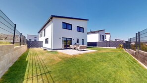 A modern two-story house with a patio, a fenced yard, and a clear blue sky. - 2BR House with private Garden & 2 Bathrooms (Kaiserslautern)
