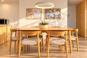 Ein Holztisch mit sechs Stühlen, ein Blumentopf und zwei gerahmte Kunstwerke an der Wand.
