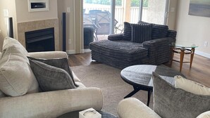 A living room with a fireplace, a flat-screen TV, a sofa, and a coffee table. - 5100 Towers Beautiful Condo! Quiet! Elevators, indoor/outdoor pools. Free Wifi (Osage Beach)