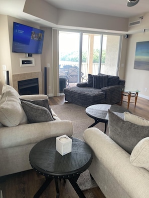 Una sala de estar con chimenea, televisor de pantalla plana, sofá y mesa de centro.