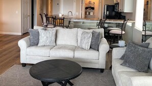A spacious living room with a sofa, coffee table, and a ceiling fan. - 5100 Towers Beautiful Condo! Quiet! Elevators, indoor/outdoor pools. Free Wifi (Osage Beach)
