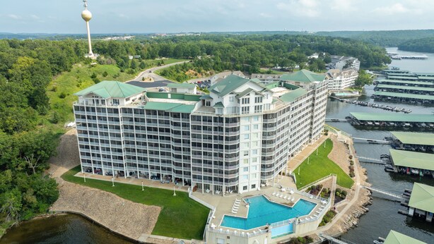 A multi-story hotel with a swimming pool, located near a body of water with docks. - 5100 Towers Beautiful Condo! Quiet! Elevators, indoor/outdoor pools. Free Wifi (Osage Beach)