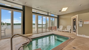 A pool area with a clear view of the outdoors, a pool with a safety ladder, and two chairs by the poolside. - 5100 Towers Beautiful Condo! Quiet! Elevators, indoor/outdoor pools. Free Wifi (Osage Beach)