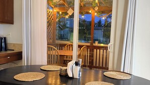 A dining area with a black table, four chairs, and a coffee maker. - Lynnwood Retreat: Office, Theater & Grapevine Deck (Lynnwood)