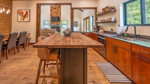 Una cocina amplia con una isla central, armarios de madera y un ventanal con vistas al exterior.