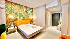Ein modernes Hotelzimmer mit einem großen Bett, einer Wanddekoration, einem Nachttisch und einer Tür zu einem weiteren Raum.