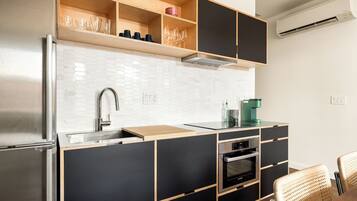 A modern kitchen with a built-in oven, a sink, and a coffee machine.