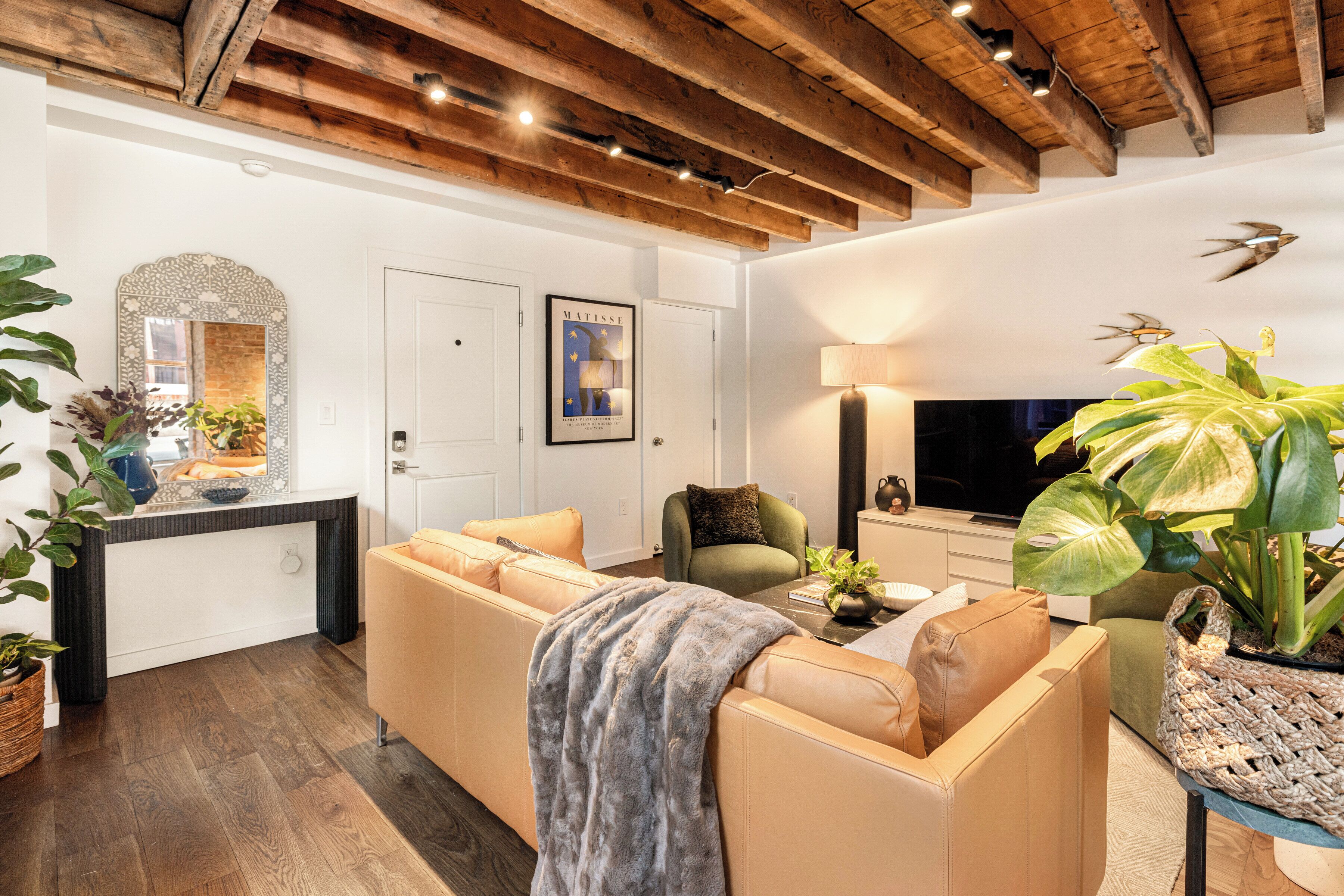 A living room with a sofa, armchair, and a television.