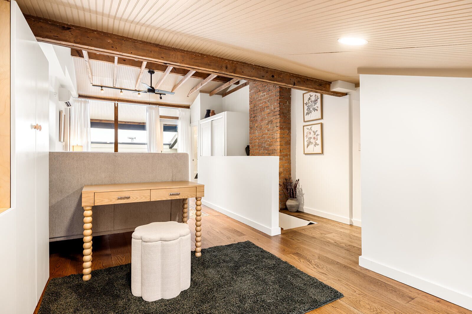 A modern kitchen with wooden beams, a built-in bench, and a small stool.
