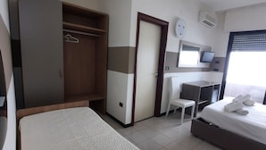 Hotellihuone, jossa on sänky, työpöytä, tuoli, vaatekaappi ja kylpyhuone.