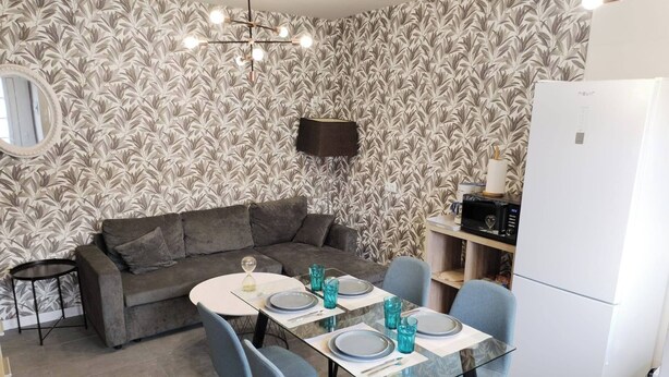 A modern living room with a sofa, dining table, chairs, and a flat-screen TV. - Charming Ground Floor Apartment With Sea Views in Bueu (Bueu)