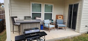 Eine Außenpatio mit Grill, Bar und Sitzgelegenheiten.