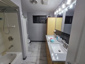 A bathroom with a shower, toilet, sink, and mirror. - Peaceful 2-bedroom house in Fairfield Township (Fairfield)