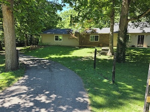A house with a paved driveway, surrounded by trees and grass. - Peaceful 2-bedroom house in Fairfield Township (Fairfield)
