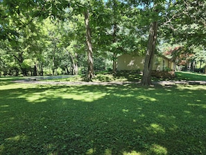 A house surrounded by lush green trees and grass.
