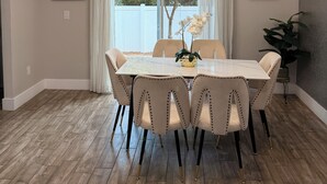 A dining area with a table, chairs, a chandelier, and artwork on the walls. - Super Calm-Sleeps 13 w Designs & close to Parks! (Kissimmee)