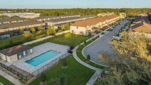 A residential area with detached houses, a swimming pool, and a well-maintained lawn. - Super Calm-Sleeps 13 w Designs & close to Parks! (Kissimmee)