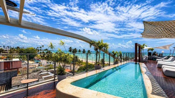 A rooftop pool with a view of the ocean and palm trees. - Setai Garden Yatch  (João Pessoa)