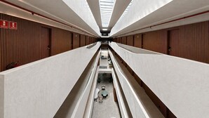A modern hotel corridor with a central walkway, wooden panel walls, and a skylight. - Setai Garden Yatch  (João Pessoa)