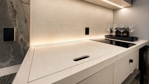 A modern kitchen with a sleek countertop, integrated lighting, and a wine glass holder. - Setai Garden Yatch  (João Pessoa)