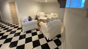 Una habitación con suelo a cuadros, paredes blancas y un ventanal.