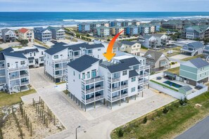 A coastal residential area with multi-story buildings, a beach, and a clear view of the ocean. - Brand New Luxury Townhome, Close to Beach w/ Pool! (Kill Devil Hills)
