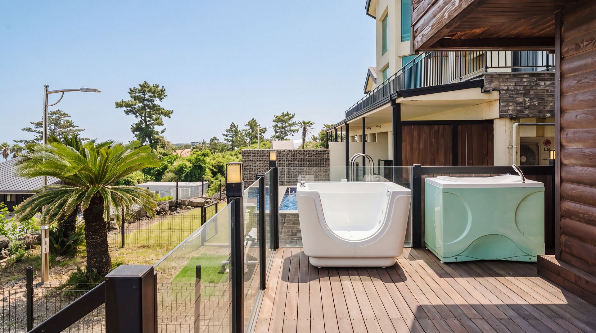 A wooden deck with a jacuzzi, a sauna, and a pool.