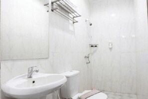 Une salle de bain équipée d’un lavabo, de toilettes et d’un espace douche.