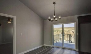 Ein Innenraum mit einer großen Schiebeglasdoor, die auf einen Balkon mit Blick auf eine Wüstenlandschaft führt.