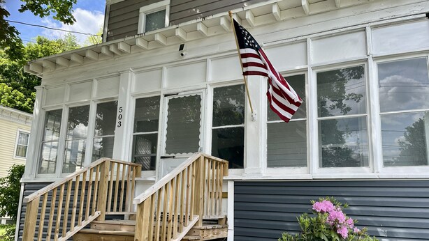 A house with a wooden staircase, a flag, and a number '503' on the wall. - Main Haven- Spacious 4BR Retreat 9 min to All star Village 21 min to Cooperstown (Oneonta)