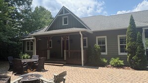 A house with a covered patio, outdoor seating, and a fire pit. - Peaceful perfection! 4-bedroom mountain lake house on Lake Adger. Near Lake Lure (Mill Spring)
