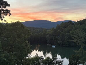 A serene lake surrounded by dense forest and hills.