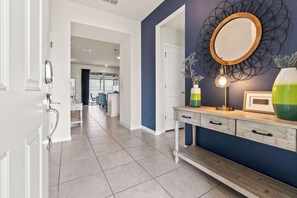 A hallway with a white door, a blue wall, and a decorative mirror. - Magical Stay at Windsor Island with pool (Davenport)