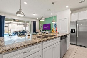A modern kitchen with granite countertops, stainless steel appliances, and pendant lighting. - Magical Stay at Windsor Island with pool (Davenport)