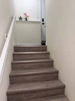 Eine Treppe mit Holzbodenstufen und einem weißen Geländer.