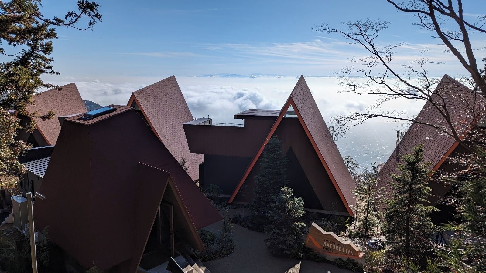A mountain lodge with triangular roofs and a clear view of the surrounding mountains.