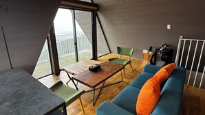 Un intérieur moderne comprenant une table à manger, des chaises, un canapé et une radio.