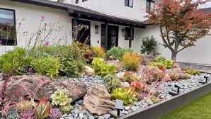 A modern house with a well-maintained garden featuring various succulents and flowering plants. - New, Quiet, Modern Comfort 3-bedroom house in tranquil Cupertino (Cupertino)