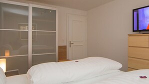 Ein Hotelzimmer mit einem Bett, einem Fernseher, einem Kleiderschrank und einer Tür.