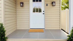 A house entrance with a white door, beige siding, and a grey porch. -  Functional and newly renovated in-law suite with private entrance and yard (Sanford)