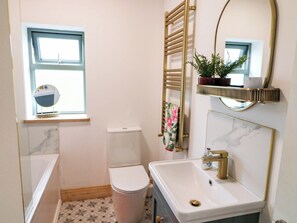 A bathroom with a toilet, sink, and a window. - KNOCKNANUSS, family friendly in Ballinascarty, County Cork (Unknown)