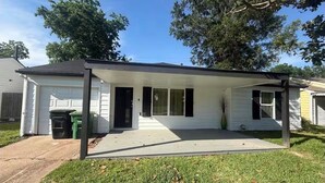 A single-story house with a covered porch, a garage, and a small front yard. - Fantastic 4BR Houston Chalet Near NRG, TSU, UofH, & Medical Center (Houston)