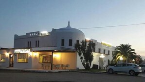 Un bâtiment avec une enseigne de restaurant, une structure en forme de dôme et des voitures garées.