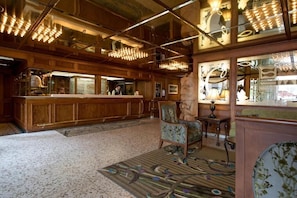 Un espace bar avec des lambris en bois, un comptoir et un tapis Ă motifs.