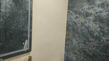 Un baño con lavamanos blanco, inodoro y espejo.