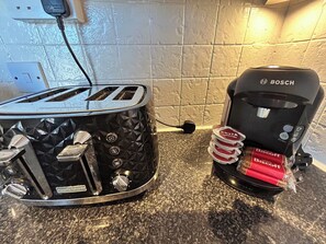 Una cucina con un tostapane e una macchina da caffè sul bancone.