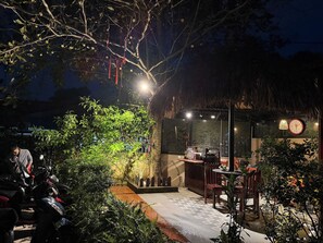 A restaurant with outdoor seating, a thatched roof, and a clock on the wall. - Sun Nova Homestay Phu Quoc (Phu Quoc)